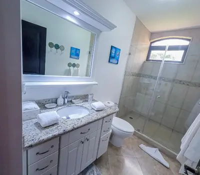 a bathroom with a sink and a shower at Luxury Walkout Beachfront Jaco Condo-Sleep 6 in Jacó