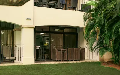 a building with a balcony with tables and chairs at Luxury Walkout Beachfront Jaco Condo-Sleep 6 in Jacó