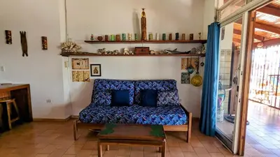 a living room with a blue couch in a room at Tico Tiki Vacation Villa - Epic View & Pool, 5 Minute walk to beach! in Sámara