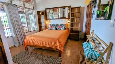 a small bedroom with a bed and a staircase at Tico Tiki Vacation Villa - Epic View & Pool, 5 Minute walk to beach! in Sámara