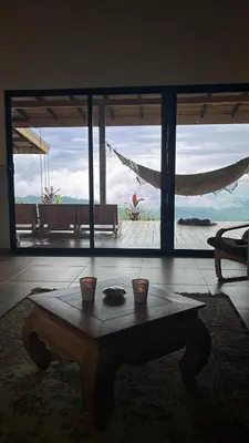 a room with a table in front of a large window at Villa Arcoiris in San Ramón
