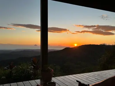 a view of the sunset from a room with a table at Villa Arcoiris in San Ramón