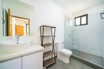 a bathroom with a sink and a toilet and a shower at CasaBlanca with Pool, 5 min from the Ocean in Cuajiniquil