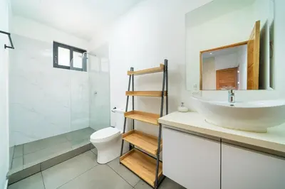 a bathroom with a sink and a toilet and a mirror at CasaBlanca with Pool, 5 min from the Ocean in Cuajiniquil