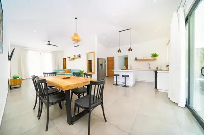 a kitchen and dining room with a wooden table and chairs at CasaBlanca with Pool, 5 min from the Ocean in Cuajiniquil
