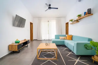 a living room with a blue couch and a table at CasaBlanca with Pool, 5 min from the Ocean in Cuajiniquil