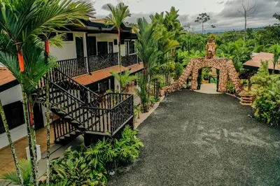 an archway leading to a house with palm trees at Arenal Palms Hot Springs in Chachagua