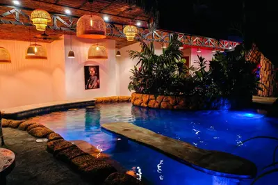 a large swimming pool in a room with lights at Arenal Palms Hot Springs in Chachagua