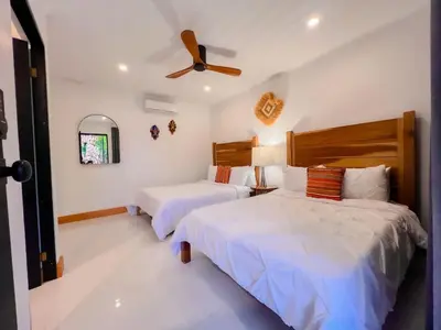 a bedroom with two beds and a ceiling fan at Arenal Palms Hot Springs in Chachagua