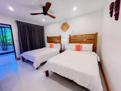 a bedroom with two beds and a ceiling fan at Arenal Palms Hot Springs in Chachagua