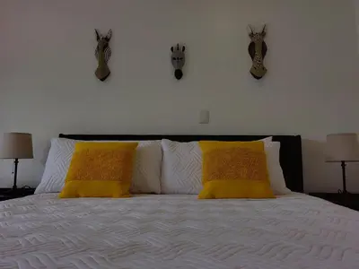 a white bed with two yellow pillows on it at Arenal Palms Hot Springs in Chachagua