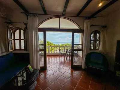 a living room with an open door to a balcony at Apt 33 Best Ocean Views Hilltop Oasis in Tamarindo