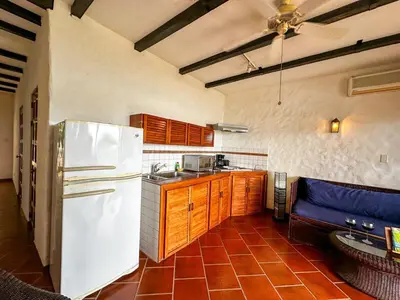 a kitchen with a white refrigerator and wooden cabinets at Apt 33 Best Ocean Views Hilltop Oasis in Tamarindo