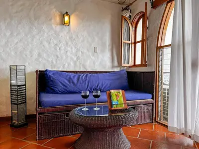 a blue couch with two wine glasses on a table at Apt 33 Best Ocean Views Hilltop Oasis in Tamarindo