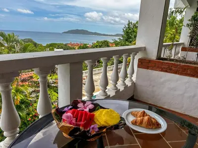 a table with two plates of food on a balcony at Apt 33 Best Ocean Views Hilltop Oasis in Tamarindo
