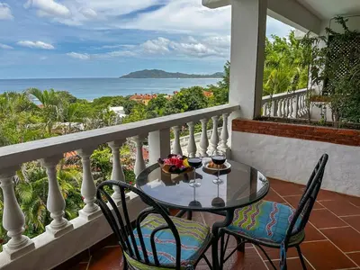 a table and chairs on a balcony with a view of the ocean at Apt 33 Best Ocean Views Hilltop Oasis in Tamarindo