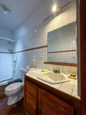 a bathroom with a sink and a toilet and a mirror at Apt 33 Best Ocean Views Hilltop Oasis in Tamarindo