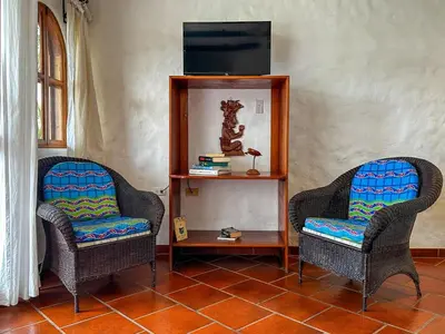 a living room with two chairs and a tv at Apt 33 Best Ocean Views Hilltop Oasis in Tamarindo