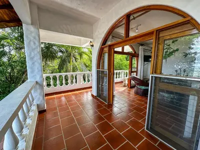 an empty house with a balcony with glass doors at Apt 47 Hilltop Retreat Ocean Garden Views in Tamarindo