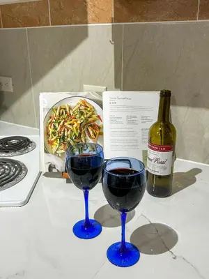 two glasses of red wine next to a bottle of wine at Apt 47 Hilltop Retreat Ocean Garden Views in Tamarindo