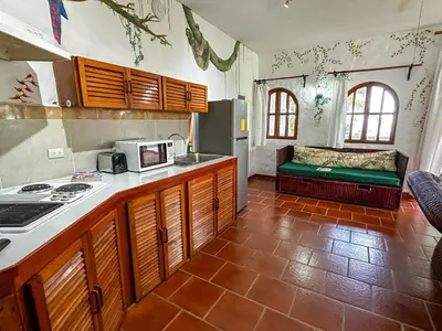a kitchen with a stove and a couch in a room at Apt 47 Hilltop Retreat Ocean Garden Views in Tamarindo