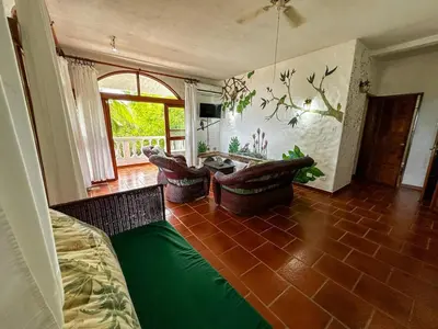 a living room with a couch and a table at Apt 47 Hilltop Retreat Ocean Garden Views in Tamarindo