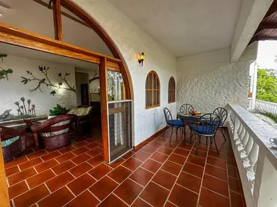 a room with a patio with a table and chairs at Apt 47 Hilltop Retreat Ocean Garden Views in Tamarindo