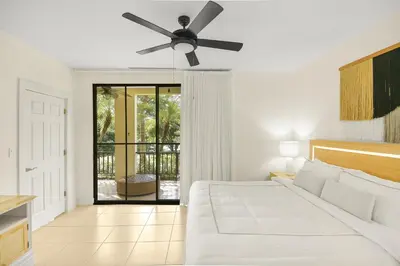 a bedroom with a bed and a ceiling fan at Palma Serena Condo, Resort Pools & Near Coco Beach in Coco