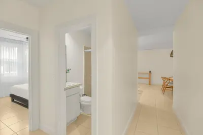 a white room with a bed and a bathroom at Palma Serena Condo, Resort Pools & Near Coco Beach in Coco