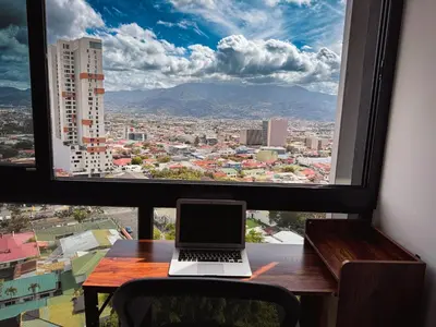 a laptop sitting on a table in front of a window at Stunning Sunset View Apartment with Free Parking in San José