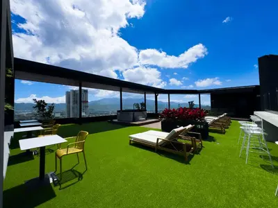 a balcony with chairs and tables on a building at Stunning Sunset View Apartment with Free Parking in San José