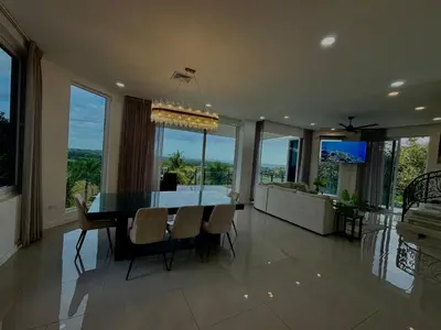 a dining room and living room with a table and chairs at Luxury 4BR home with Infinity Pool & firepit in Playa Hermosa