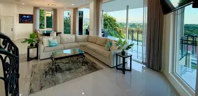 a living room with a couch and a table at Luxury 4BR home with Infinity Pool & firepit in Playa Hermosa