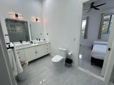 a bathroom with a toilet and a sink and a mirror at Luxury 4BR home with Infinity Pool & firepit in Playa Hermosa