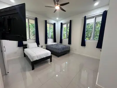 a bedroom with a bed and a flat screen tv at Luxury 4BR home with Infinity Pool & firepit in Playa Hermosa