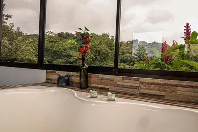 a bathroom with a bath tub in front of a window at Volcano & Lake View Oasis with Scenic Tub in El Castillo de La Fortuna
