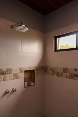 a bathroom with a shower with a window at Volcano & Lake View Oasis with Scenic Tub in El Castillo de La Fortuna