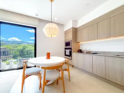 a kitchen with a table and chairs and a large window at Kamin Casa, Ocean Views & Beach Club in Sardinal