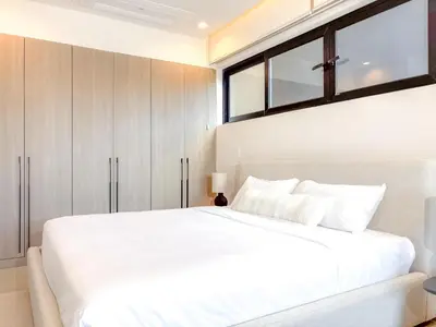 a bedroom with a large white bed and a window at Kamin Casa, Ocean Views & Beach Club in Sardinal