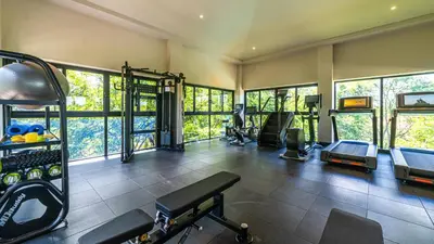 a gym with several treadmills and machines in a room at Loma Mar at Naumi, Ocean Views & Beach Club in Sardinal