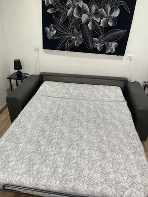 a bed in a living room with a picture on the wall at Hidden House Casa Escondida in Santa Rosa