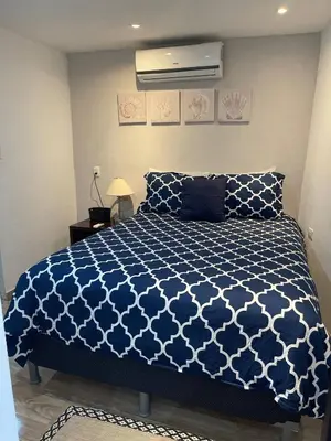 a bedroom with a bed with a blue and white comforter at Hidden House Casa Escondida in Santa Rosa