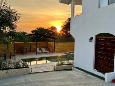a house with a pool and a sunset in the background at Casa Blanca Manuel Antonio A1, Central, Pool, Gated in Manuel Antonio
