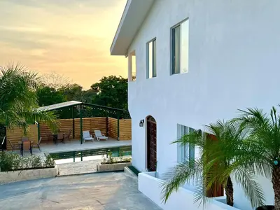 a white house with a patio and a deck at Casa Blanca Manuel Antonio A1, Central, Pool, Gated in Manuel Antonio