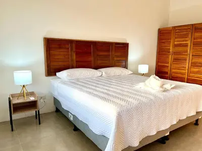 a bedroom with a large bed with a wooden headboard at Casa Blanca Manuel Antonio B2, Central, Pool, Gated in Manuel Antonio