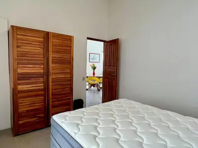 a bedroom with a white bed and a wooden closet at Casa Blanca Manuel Antonio B2, Central, Pool, Gated in Manuel Antonio