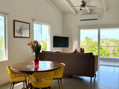 a living room with a couch and a table and chairs at Casa Blanca Manuel Antonio B2, Central, Pool, Gated in Manuel Antonio