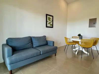 a living room with a blue couch and a table at Casa Blanca Manuel Antonio A3 in Manuel Antonio