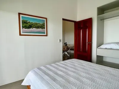 a bedroom with a bed and a picture on the wall at Casa Blanca Manuel Antonio A3 in Manuel Antonio