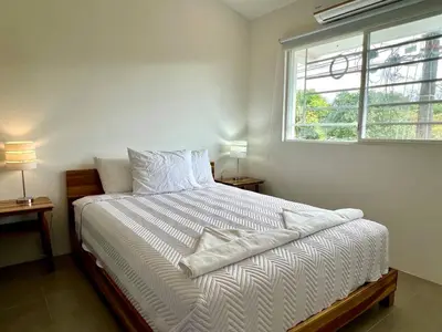 a white bed in a bedroom with a window at Casa Blanca Manuel Antonio A3 in Manuel Antonio